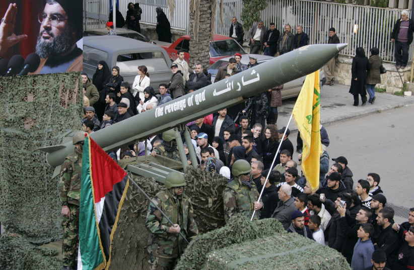 Hezbollah members carry mock missile during procession held to celebrate Ashura in south Lebanon, 2009 (credit: ALI HASHISHO/REUTERS)