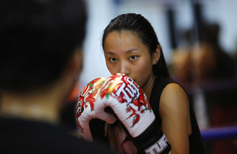 Woman attends a boxing class at Princess Women's Boxing Club in Shanghai (photo credit: CARLOS BARRIA / REUTERS)