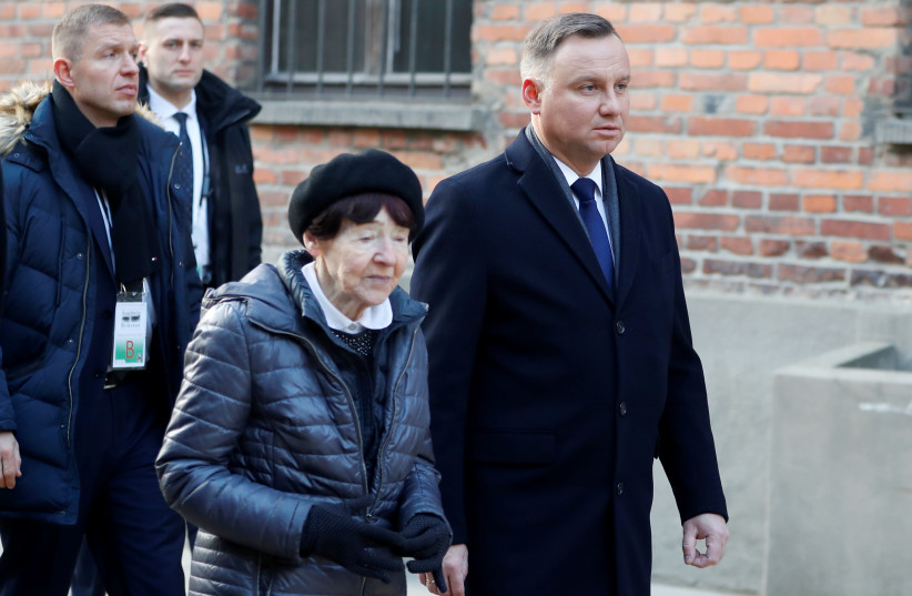Poland's President Andrzej Duda and Zofia Optulowicz, daughter of Polish cavalry captain and World War II resistance leader Witold Pilecki, arrive to attend a wreath-laying ceremony at the "death wall" at the former Nazi German concentration and extermination camp Auschwitz, January 27, 2020. (photo credit: REUTERS/ALEKSANDRA SZMIGIEL)
