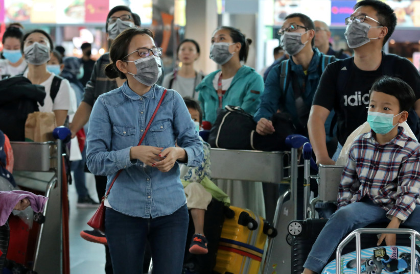 Passengers wearing masks are seen at Kuala Lumpur International Airport 2 in Sepang, Malaysia, January 27, 2020 (photo credit: REUTERS/LIM HUEY TENG)