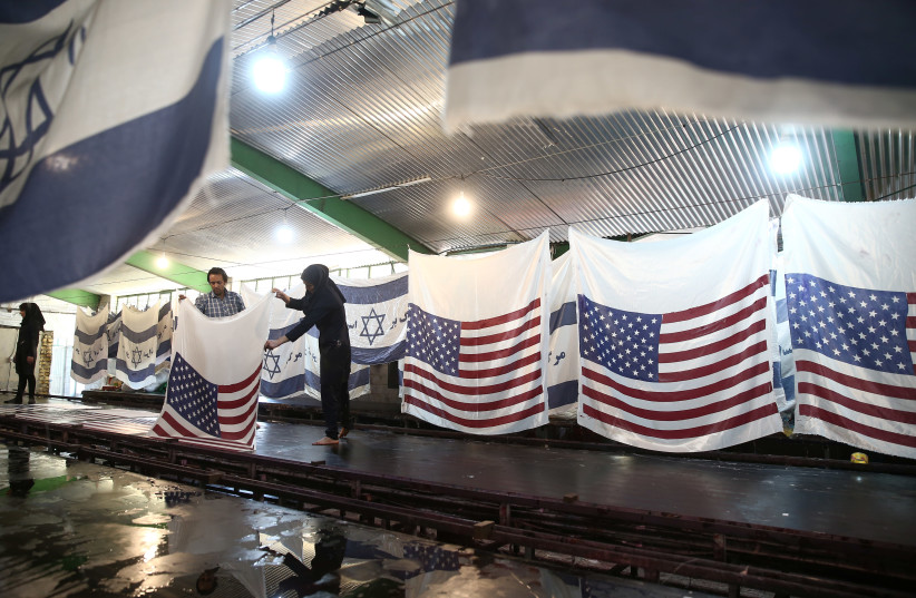 Iranian workers collect U.S. flags after making them at a large flag factory which creates U.S. and Israeli flags for Iranian protesters to burn in Khomein City, Iran January 28, 2020 (photo credit: NAZANIN TABATABAEE/WANA (WEST ASIA NEWS AGENCY) VIA REUTERS)