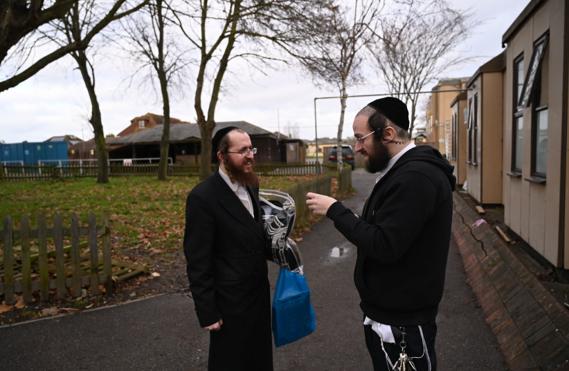 Jacob Gross, right, speaking to a resident of Canvey Island, UK outside the town's synagogue on Dec. 13, 2019.  (photo credit: CNAAN LIPHSHIZ/JTA)