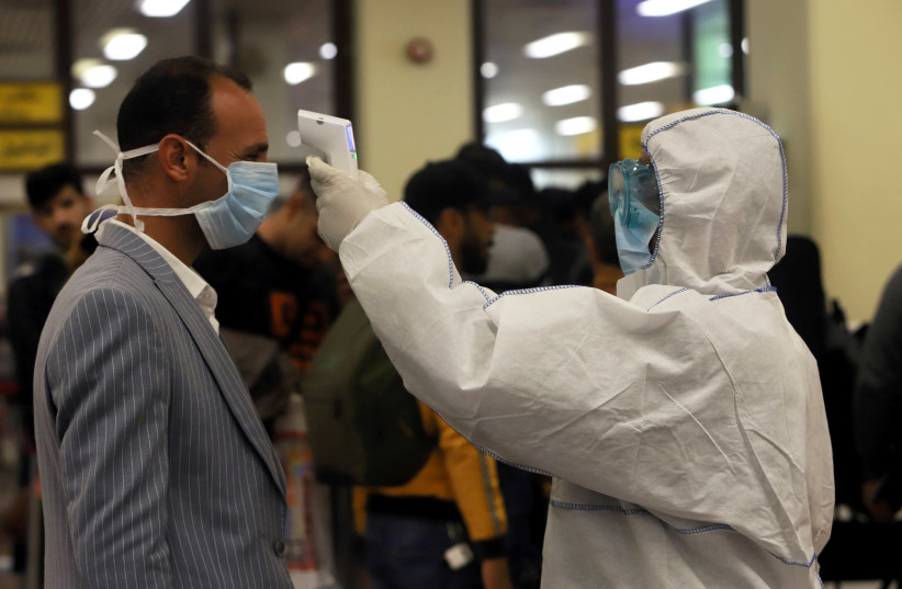 Passengers wearing masks, amid the new coronavirus outbreak, are checked by Iraqi Health Ministry employees upon their arrival at Basra airport, in Basra, Iraq February 1, 2020 (photo credit: REUTERS/ESSAM AL-SUDANI)