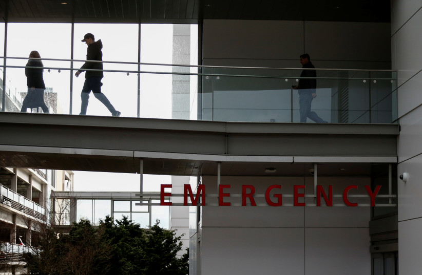 People walk on a skybridge from the emergency room building at Providence Regional Medical Center after a spokesman from the U.S. Centers for Disease Control and Prevention (CDC) said a traveler from China has been the first person in the United States to be diagnosed with the Wuhan coronavirus, in  (photo credit: REUTERS/LINDSEY WASSON)