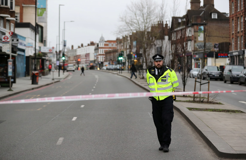 A police officer is seen near a site where a man was shot by armed officers in Streatham, south London, Britain, February 2, 2020. (photo credit: ANTONIO BRONIC/ REUTERS)