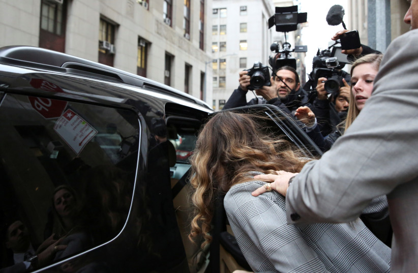 Witness Lauren Young hides her face from photographers as she departs the Criminal Court after testifying during the Harvey Weinstein sexual assault trial trial in the Manhattan borough of New York City (photo credit: REUTERS/CAITLIN OCHS)
