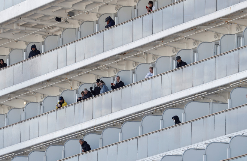Passengers watch as ambulances transfer passengers, who tested positive for coronavirus, from the cruise ship Diamond Princess to a hospital, after the ship arrived at Daikoku Pier Cruise Terminal in Yokohama, south of Tokyo, Japan February 6, 2020 (photo credit: REUTERS/KIM KYUNG-HOON)