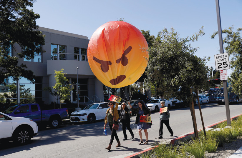 DEMONSTRATORS CARRY an inflatable angry emoji during a protest outside the Facebook annual shareholders meeting in California in May 2019.  (photo credit: STEPHEN LAM / REUTERS)