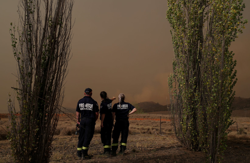 Personnel from Fire and Rescue NSW monitor a bushfire as it approaches a home in Bredbo, New South Wales, Australia, February 1, 2020. (photo credit: LOREN ELLIOTT/REUTERS)