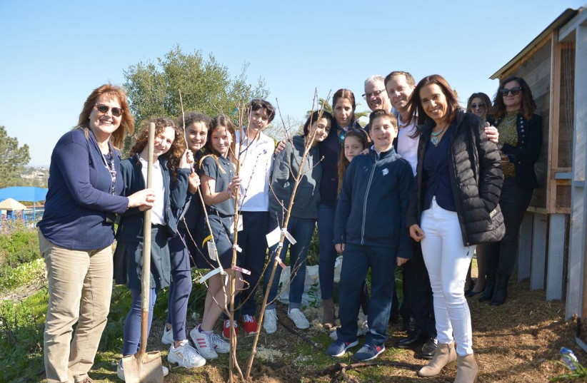 Isaac Herzog with Hagit Hemo, mother of Ori, the lone soldier from San Diego injured in the ramming attack in Jerusalem, plant a tree with students at the San Diego Jewish Academy where Ori attended before making Aliyah and where his mother teaches Hebrew.  (photo credit: MARK GARCIA)