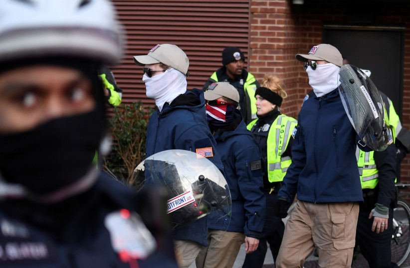 Police escort the last of about 150 masked members of the Patriot Front from a parking garage, after they peacefully ended a march near Capitol Hill, in Washington, Feb. 8, 2020 (credit: MIKE THEILER/REUTERS)