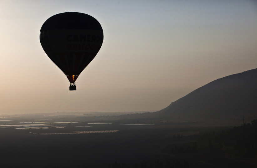 A hot air balloon soars over the Jezreel Valley in northern Israel (photo credit: REUTERS)