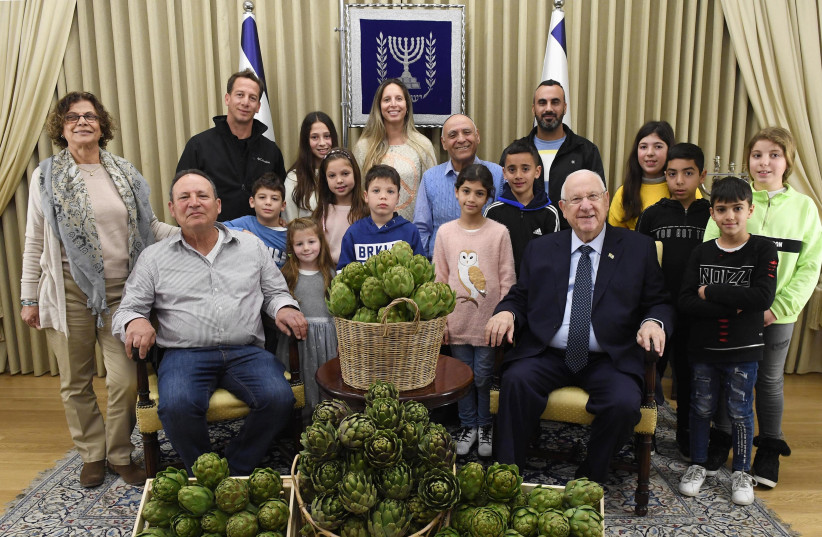 Rivlin pictured with three families of Israeli artichoke farmers (photo credit: MARK NEYMAN/GPO)