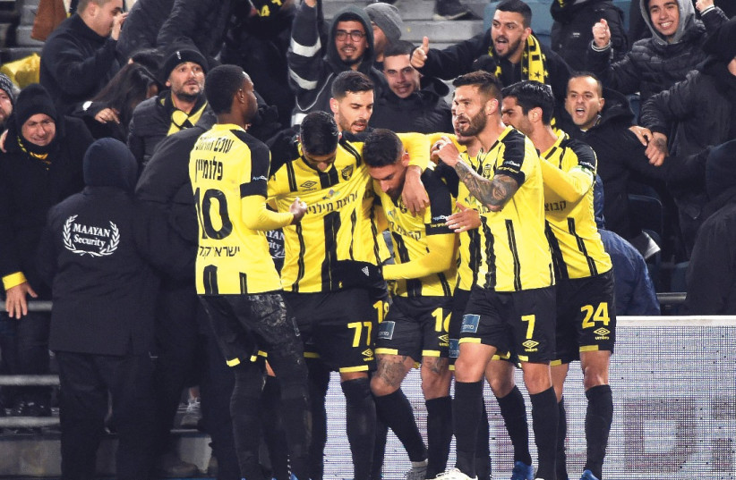 BEITAR JERUSALEM players celebrate with Eliran Atar (center) after the forward scored on a 26th-minute penalty in his first match with the club to help the yellow-and-black beat Maccabi Haifa 2-0 last night in Israel Premier League action at Teddy Stadium (photo credit: BERNEY ARDOV)
