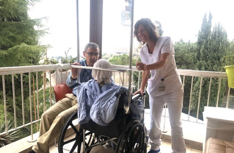 Director of palliative care services Dr. Daniel Azoulay and head nurse of the Hospice in Hadassah Mount Scopus Gal Sapir spend time with a patient (photo credit: HADASSAH MOUNT SCOPUS)
