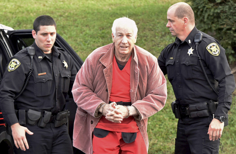 CONVICTED CHILD molester Jerry Sandusky (center), a coach at Penn State University, arrives at a Pennsylvania courthouse in 2015 (photo credit: REUTERS)