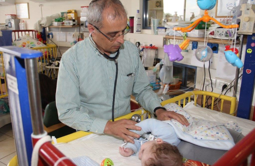 Dr. Eliezer Be’eri shown treating infant with CoughSync (photo credit: NOAH ARAD)