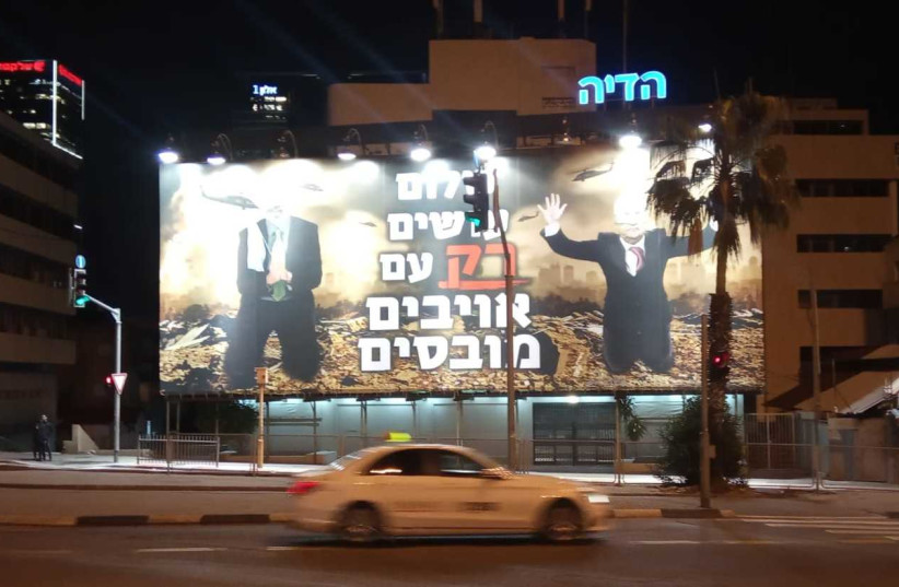 A sign in Tel Aviv with the words Peace can only be reached with vanquished enemies.” The people being shown on their knees are Palestinian Authority President Mahmoud Abbas and Hamas leader Islmail Haniyeah (photo credit: HAGAY HACOHEN)