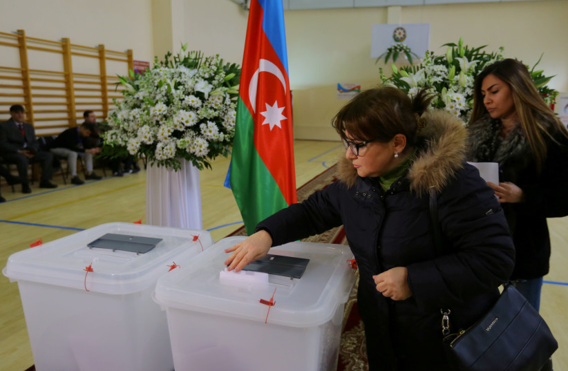 A woman casts her vote at a polling station during a snap parliamentary election in Baku, Azerbaijan February 9, 2020. (photo credit: REUTERS/AZIZ KARIMOV)