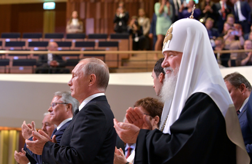 Russian President Putin and Patriarch Kirill applaud during the inaugural ceremony of Moscow Mayor Sergei Sobyanin at the Zaryadye Concert Hall in Moscow (photo credit: REUTERS)