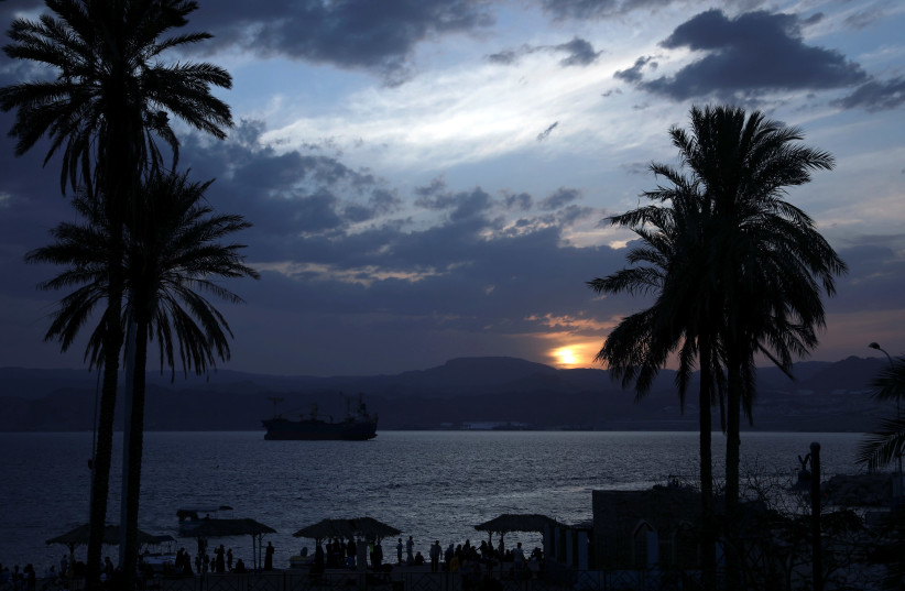 People are seen as the sun sets over a beach in the Aqaba Gulf on the Red Sea, south of Amman (photo credit: REUTERS)
