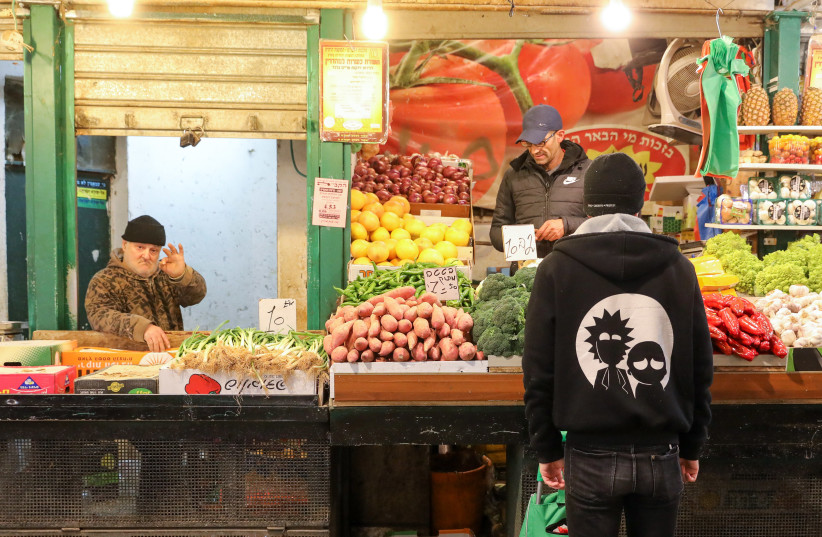 A man is seen buying produce at one of the vendors at the Mahaneh Yehuda shuk in Jerusalem. (photo credit: MARC ISRAEL SELLEM/THE JERUSALEM POST)