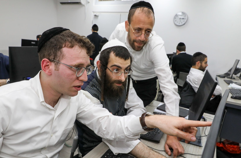 Avratech director Aaron Safrai (right) is pictured with ultra-Orthodox Jewish students learning computer programming at Avratech's Jerusalem offices (photo credit: MARC ISRAEL SELLEM)