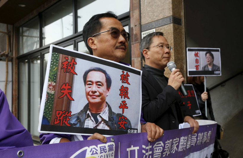 Members from the pro-democracy Civic Party carry a portrait of Lee Bo and Gui Minhai before they protest outside Chinese Liaison Office in Hong Kong (photo credit: REUTERS)