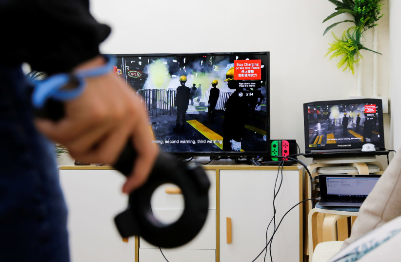 A member of a game developers team demonstrates a video game called "Liberate Hong Kong", that simulates the current anti-government protests, in Hong Kong (photo credit: REUTERS)