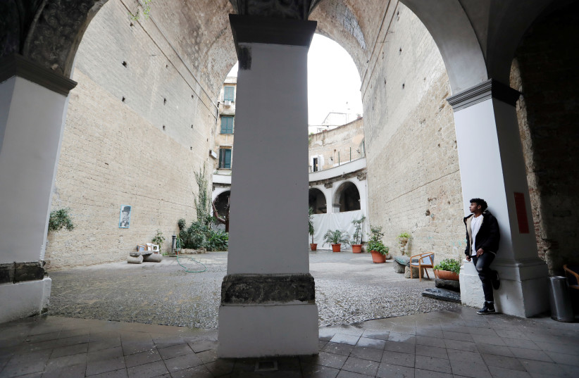 Nico Rodrigues, 21, looks into the sky outside the chapel of the Santa Maria della Sanita Basilica in the Rione Sanita neighbourhood in Naples (photo credit: REUTERS)