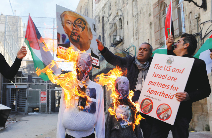 PALESTINIAN DEMONSTRATORS burn effigies depicting US President Donald Trump and Prime Minister Benjamin Netanyahu during a protest in Hebron last week. (photo credit: REUTERS/MUSSA QAWASMA)