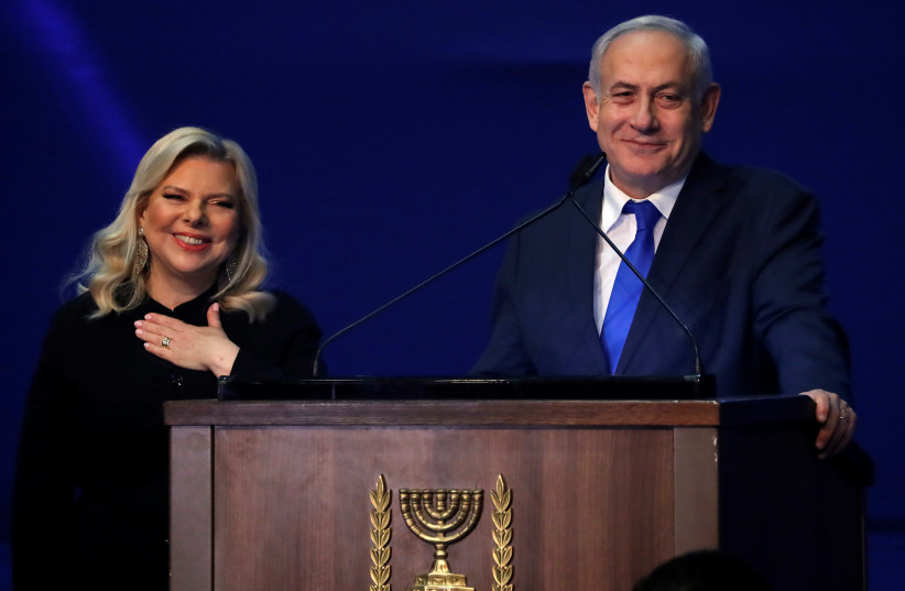 Israeli Prime Minister Benjamin Netanyahu and his wife Sara react following the announcement of exit polls in Israel's election at his Likud party headquarters in Tel Aviv (photo credit: REUTERS)