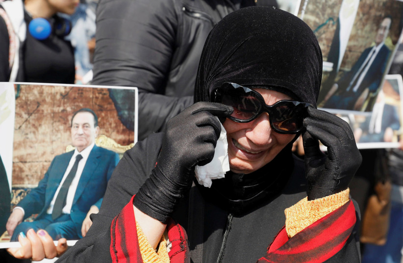 A MUBARAK supporter mourns near the main gate of a cemetery during the leader’s burial ceremony, east of Cairo on February 26.  (photo credit: REUTERS)
