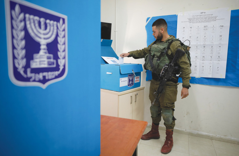 A SOLDIER casts his ballot on Monday at a mobile polling station near Kibbutz Zikim in the South.  (photo credit: AMIR COHEN/REUTERS)