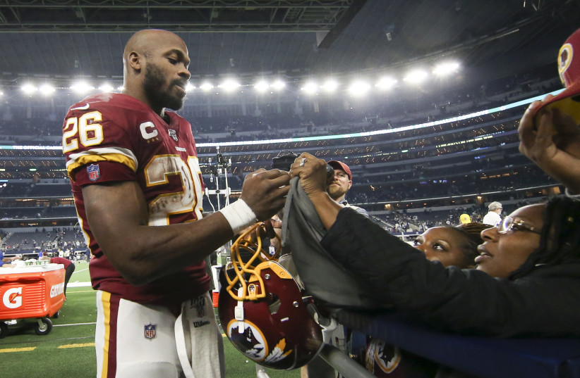 Washington Redskins running back Adrian Peterson (26) signs autographs after the game against the Dallas Cowboys at AT&T Stadium.  (photo credit: USA TODAY)