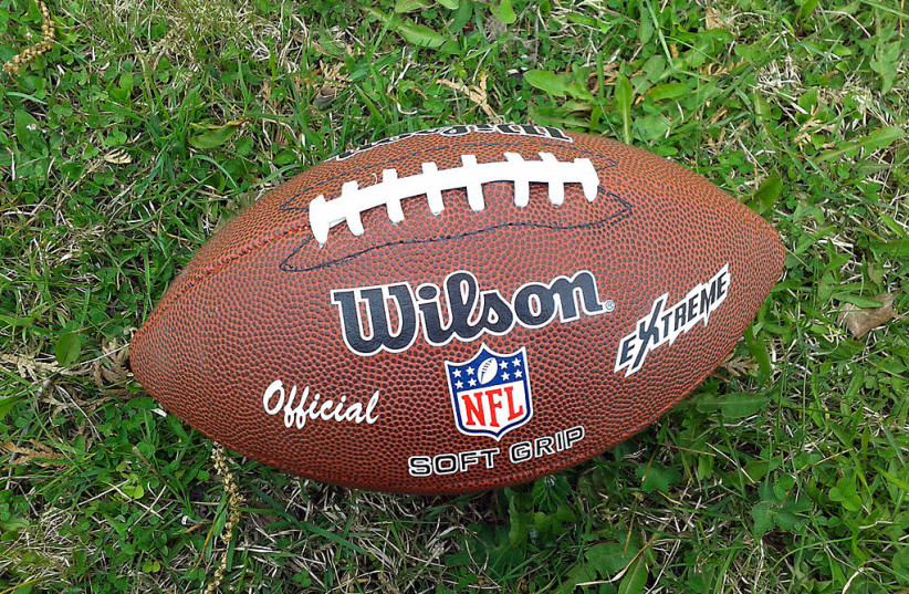 A football is seen with the NFL logo. (credit: Wikimedia Commons)