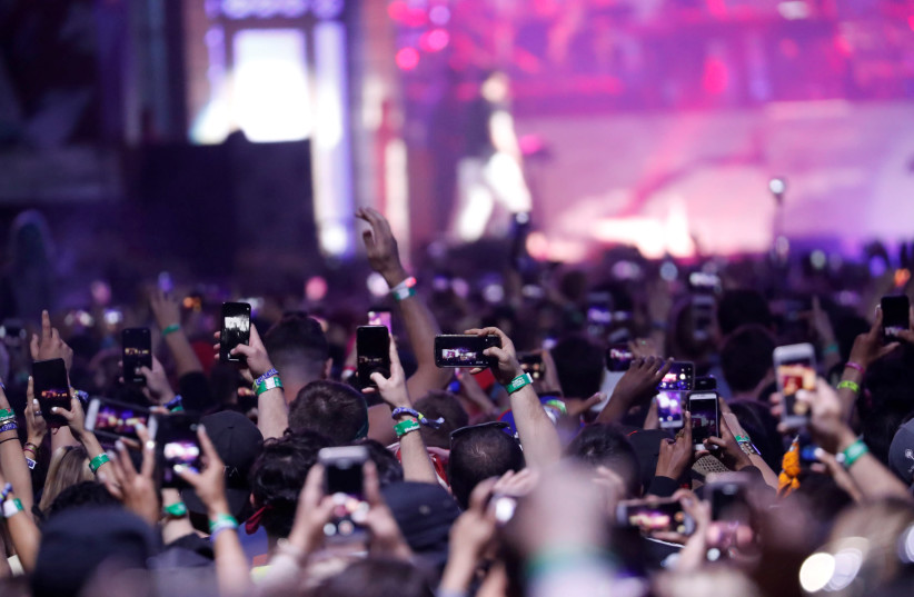 Concertgoers use their mobile phones during Eminem's performance at the Coachella Valley Music and Arts Festival in Indio (photo credit: REUTERS)
