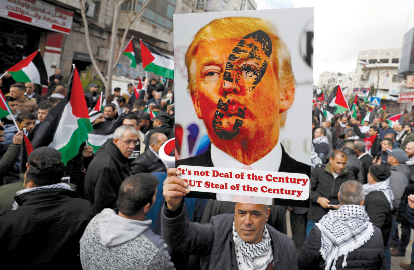 A PALESTINIAN demonstrator holds an anti-US President Donald Trump poster during a rally in support of Abbas and against Trump’s Middle East peace plan, in Ramallah on February 11. (photo credit: REUTERS)