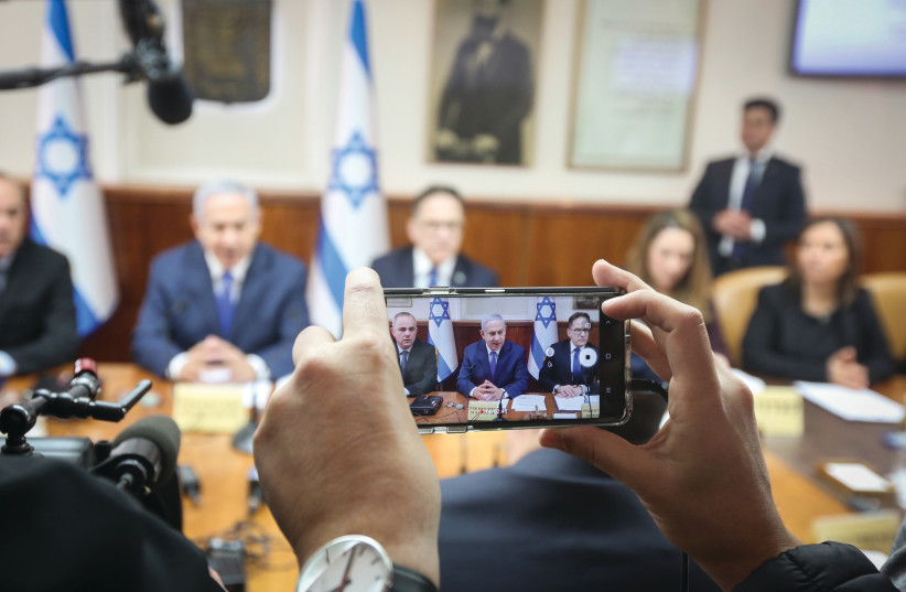 A REPORTER RECORDS Prime Minister Benjamin Netanyahu at a cabinet meeting. (photo credit: MARC ISRAEL SELLEM/THE JERUSALEM POST)