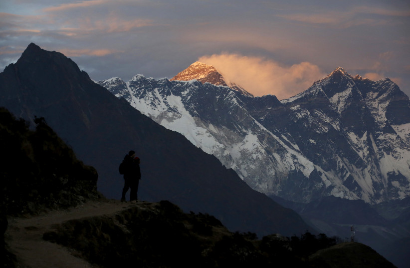 Light illuminates Mount Everest (C) during sunset in Solukhumbu district, also known as the Everest region, in this picture taken November 30, 2015 (credit: REUTERS/NAVESH CHITRAKAR/FILE PHOTO)