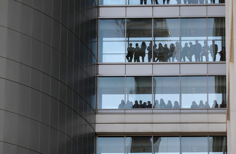 People look out from the windows of the Defense Ministry. (photo credit: REUTERS/AMIR COHEN)