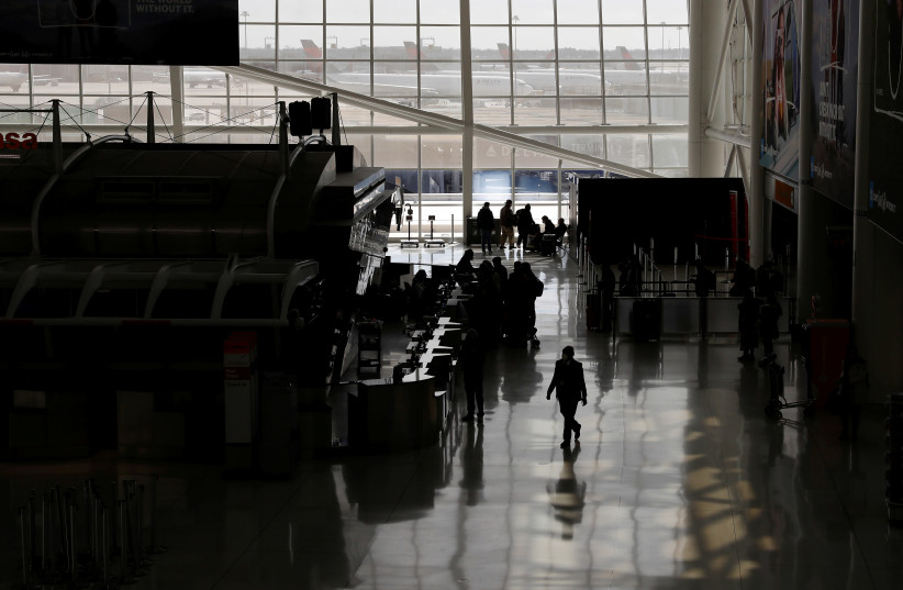 Air travelers walk, after further cases of coronavirus were confirmed in New York, in Terminal 1 at JFK International Airport in New York (photo credit: REUTERS)