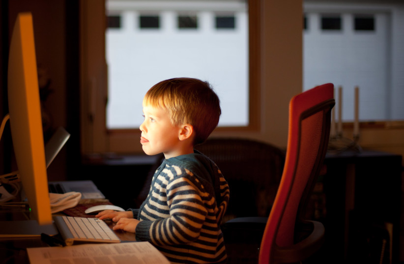 A child sits at the computer (photo credit: FLICKR)
