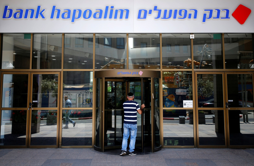 A man enters the main branch of Bank Hapoalim, Israel's biggest bank, in Tel Aviv, Israel July 18, 2016. Picture taken July 18, 2016 (credit: AMIR COHEN/REUTERS)