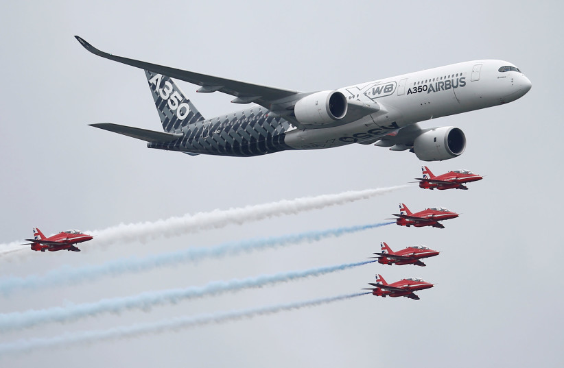 An Airbus A350 aircraft flies in formation with Britain's Red Arrows flying display team at the Farnborough International Airshow in Farnborough, Britain July 15, 2016 (photo credit: PETER NICHOLLS/REUTERS)