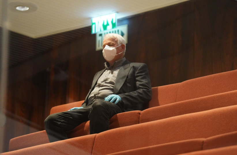 Blue and White MK Alon Schuster getssworn into the Knesset from the press gallery wearing masks and gloves, March 23, 2020 (photo credit: KNESSET SPOKESPERSON'S OFFICE)