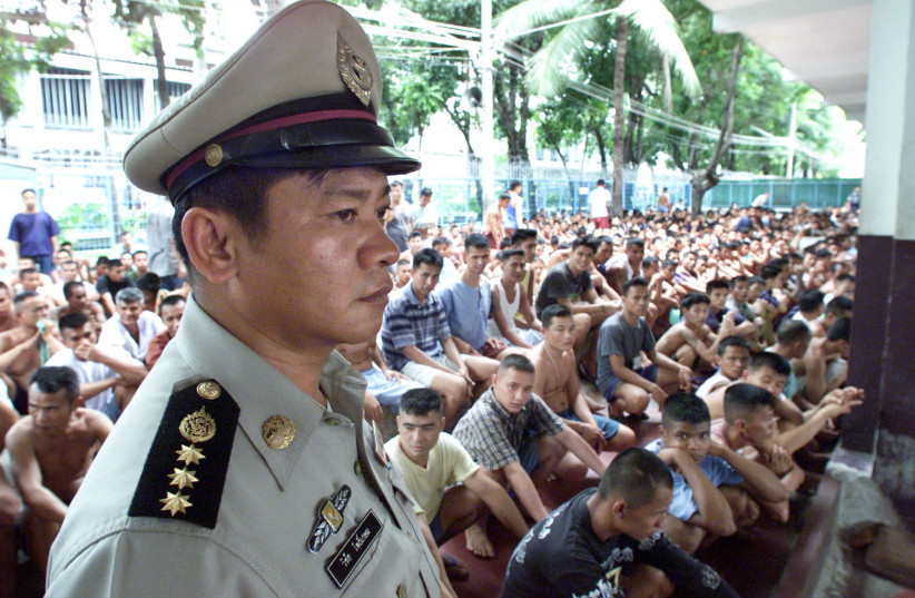 A prison guard watches over hundreds of inmates crammed into the overcrowded Klongprem prison in Bangkok August 22, 2000 where over 6,200 inmates are serving sentences on drug-related charges (photo credit: JIR/PB VIA REUTERS)