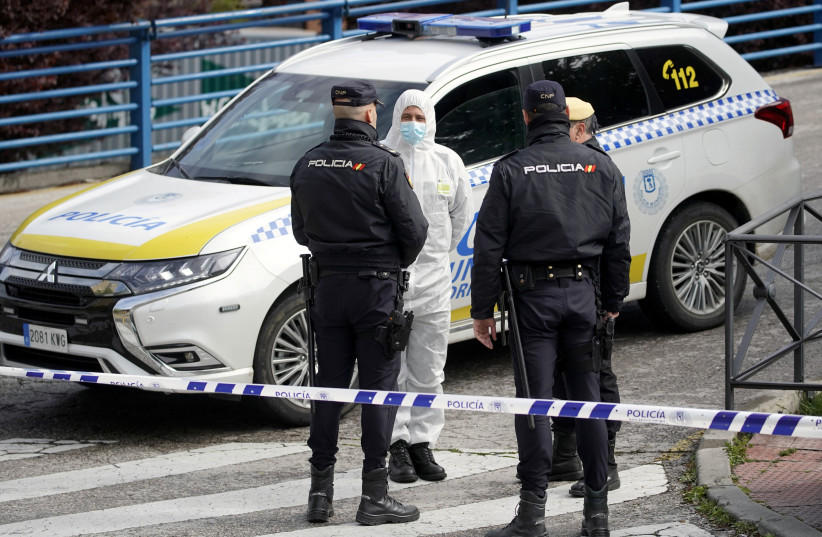 A member of the Spanish army talks with Spanish National policemen outside an ice rink which will be used as a morgue, during the coronavirus disease (COVID-19) outbreak in Madrid, Spain, March 24, 2020 (photo credit: REUTERS)