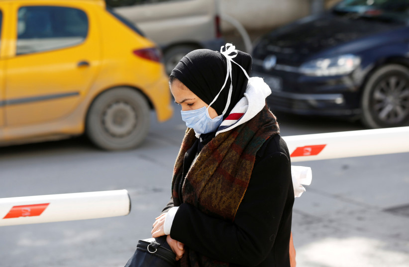 A woman wears a protective face mask as she walks in Tunis, Tunisia March 4, 2020 (credit: REUTERS/ZOUBEIR SOUISSI)