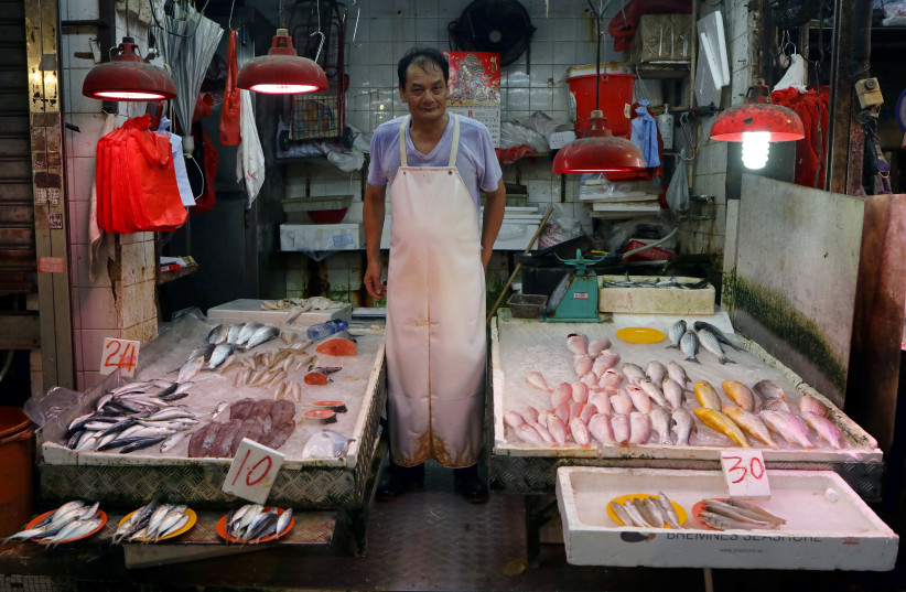 A vendor works at a wet market in China (photo credit: REUTERS)
